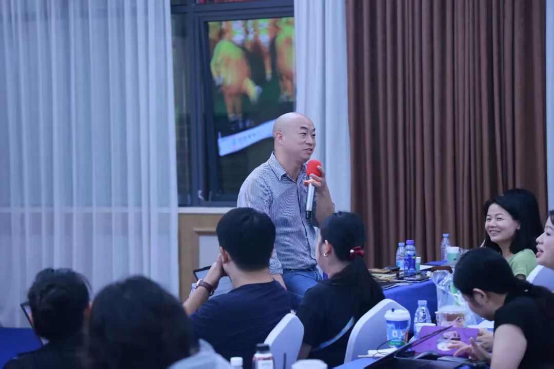 学员在现场用麦克风分享自己的外贸经验